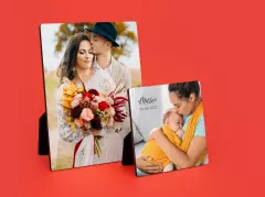 Zwei personalisierte Fotoaufsteller mit Hochzeitsfoto und Babyfoto auf rotem Hintergrund.