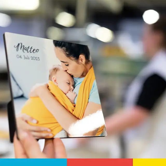 Personalisierter Fotohalter mit Babyfoto wird in der Hand gehalten, glänzende Oberfläche im Fokus.