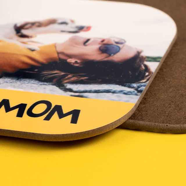 Nahaufnahme eines personalisierten Untersetzers mit Foto und gelbem Rand, Schriftzug „Mom“.