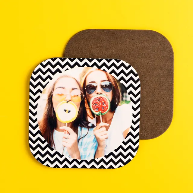 Zwei Frauen mit Lollis posieren auf einem personalisierten Untersetzer mit Zickzackmuster auf gelbem Hintergrund.