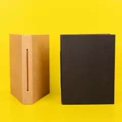Kleines Fotoalbum – verschiedene Bindungen und natürliche Materialien im Vergleich Zwei kleine Fotoalben im Hochformat: Das schwarze Album zeigt sein schlichtes Cover, das hellbraune offenbart eine Bindung aus Kordel, die den Einband zusammenhält.