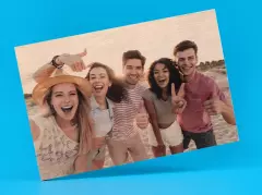 Rechteckige Holzplatte mit einem Freunde-Schnappschuss aus dem Urlaub. Bei dem Bild auf Holz scheint die natürliche Holzstruktur des hellen Holzes durch. 