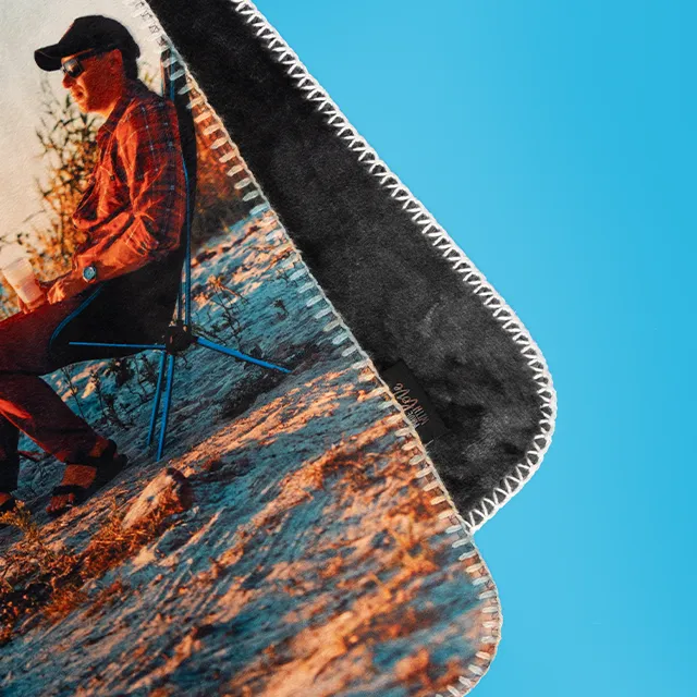 Fotodecke mit Campingmotiv und weicher, dunkler Rückseite in Nahaufnahme.