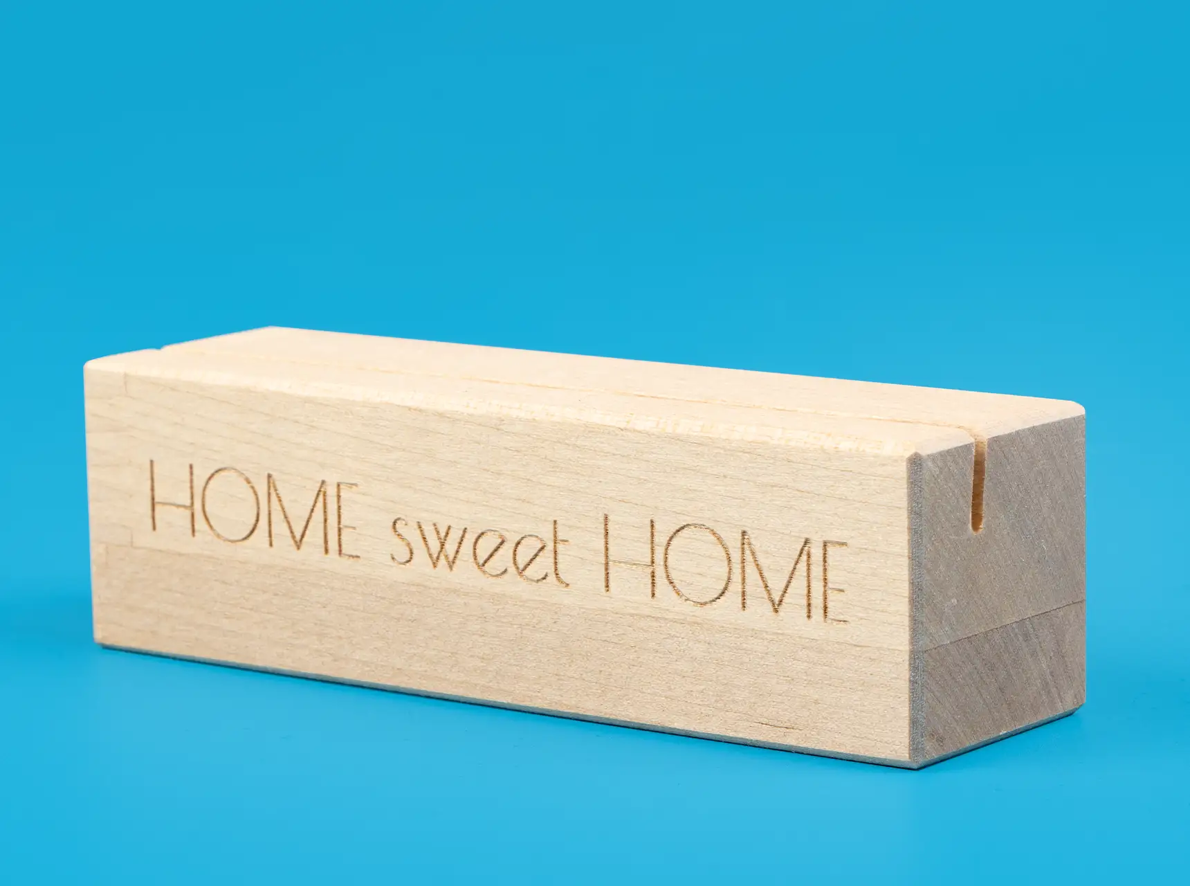 Schlichter Fotohalter aus Holz mit Schlitz für Fotos oder Postkarten auf rotem Hintergrund.