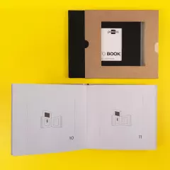 Elegante Einsteckalben mit Passepartout und hochwertiger Verpackung Weißes Einsteckalbum geöffnet, Seiten mit Passepartouts. Daneben ein geschlossenes schwarzes Album mit brauner Schutzbox aus Kraftpapier.