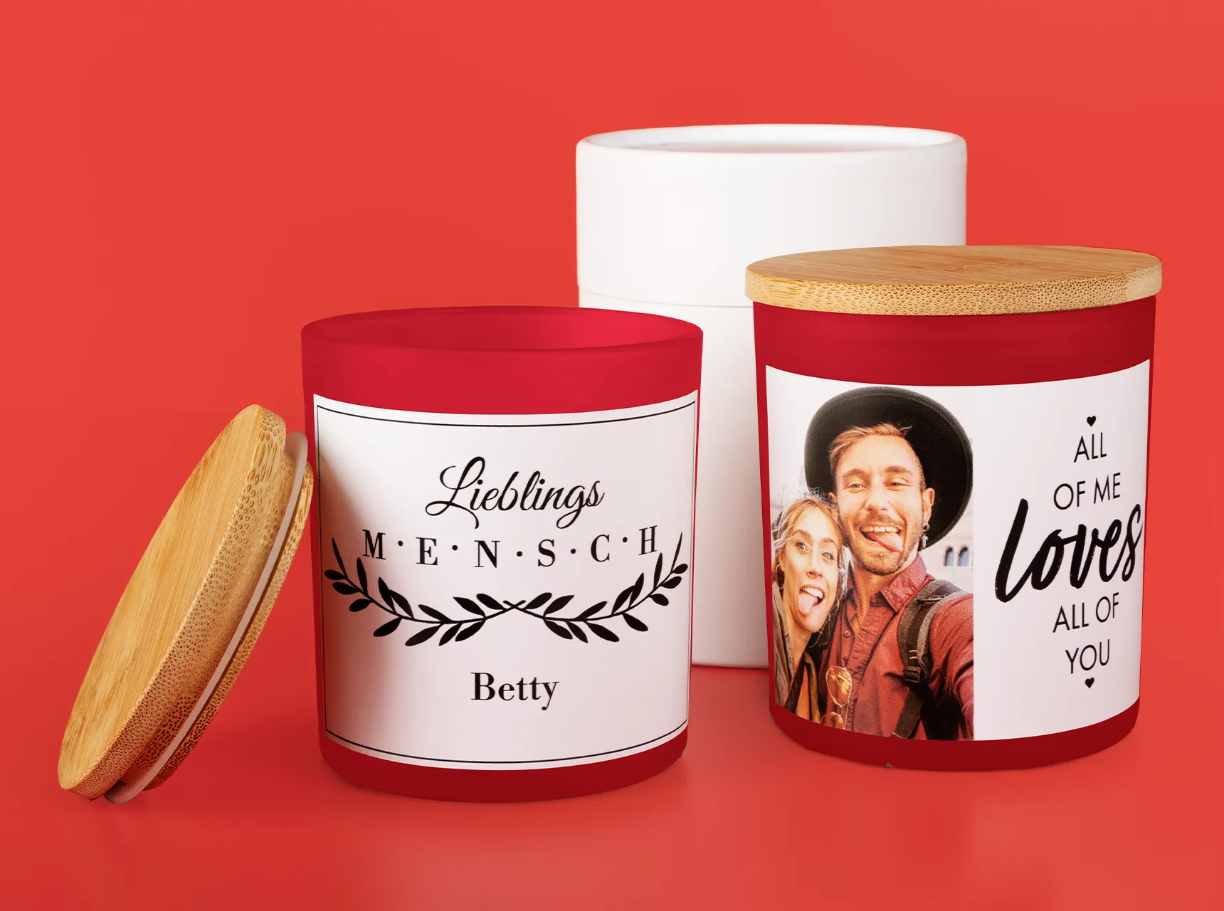 Zwei Duftkerzen, personalisiert mit Foto und Spruch. Beide Kerzen im Glas haben einen Bambusdeckel. Im Hintergrund steht eine weiße Verpackung.