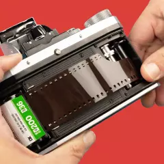 Ein Film wird in eine analoge Kamera eingelegt. Diese Filme können hier bei ORWO entwickelt werden. Analoge Kamera mit Filmrolle