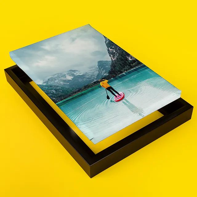 Moderne Leinwand mit Rahmen in elegantem Schwarz, auf der ein Reisefoto mit See, Bergen und einer Person beim Stand-Up-Paddling zu sehen ist – eindrucksvolle Präsentation als hochwertige Fotoleinwand mit Rahmen.