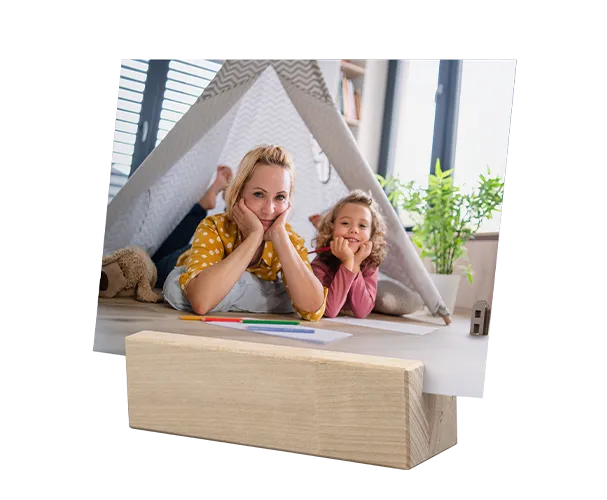 Foto einer Mutter mit Kind unter einem Spielzelt, präsentiert in einem Holz-Fotohalter von ORWO.