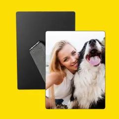 Frau macht ein Selfie mit ihrem Hund auf einem personalisierten Fotoaufsteller, gelber Hintergrund.